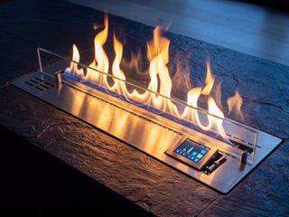 Brûleur bioéthanol automatique Flamvia allumé, encastré dans une niche en ardoise, écran tactile visible