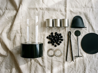 Contenu du kit complet : cheminée cylindre de verre, trois réservoirs inox, galets noirs, bagues, pince, gant, éteignoir et dessous de protection