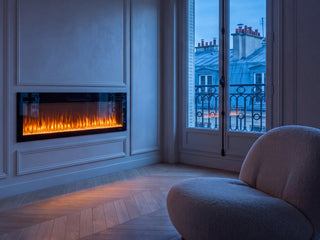 Cheminée électrique murale Slim Full Glass encastrée dans un mur à moulures, salon haussmannien à l'heure bleue
