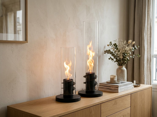 Les deux tailles de la cheminée de table à flamme tourbillon, 40 cm et 56 cm, côte à côte sur un buffet en chêne